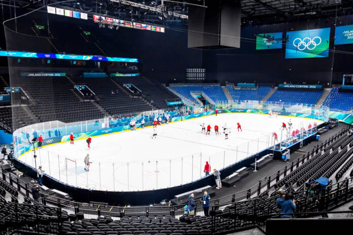 campanili-ditalia_paralimpiadi-milano-cortina-2026_arena-santa-giulia_web Arena del PalaItalia Santa Giulia a Milano durante i preparativi per le Paralimpiadi Milano Cortina 2026, con pista da hockey su ghiaccio, atleti in allenamento e tribune illuminate con il logo olimpico