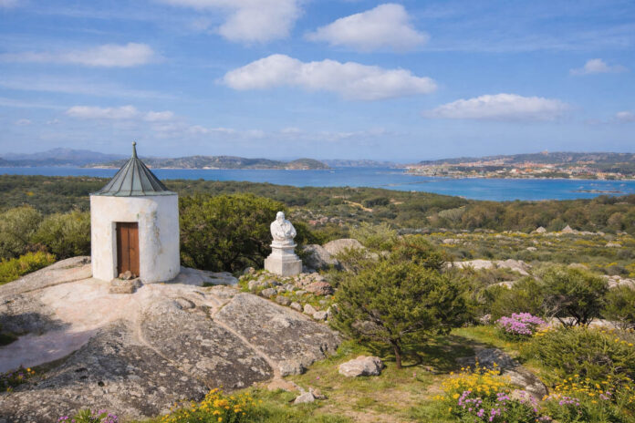 Torre bianca e busto di Garibaldi su roccia granitica a Caprera con vista sul mare della Maddalena