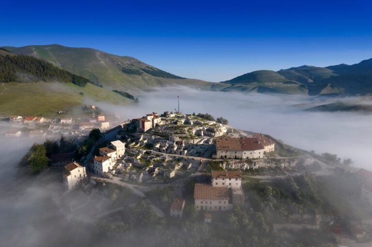 Piani di Castelluccio in fioritura con strisce di papaveri rossi e fiordalisi azzurri sul Pian Grande in Umbria