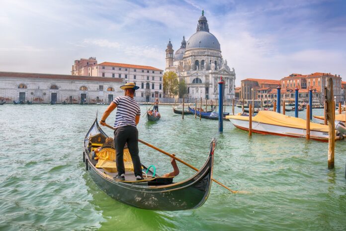 Uomo su una gondola con vista su Venezia